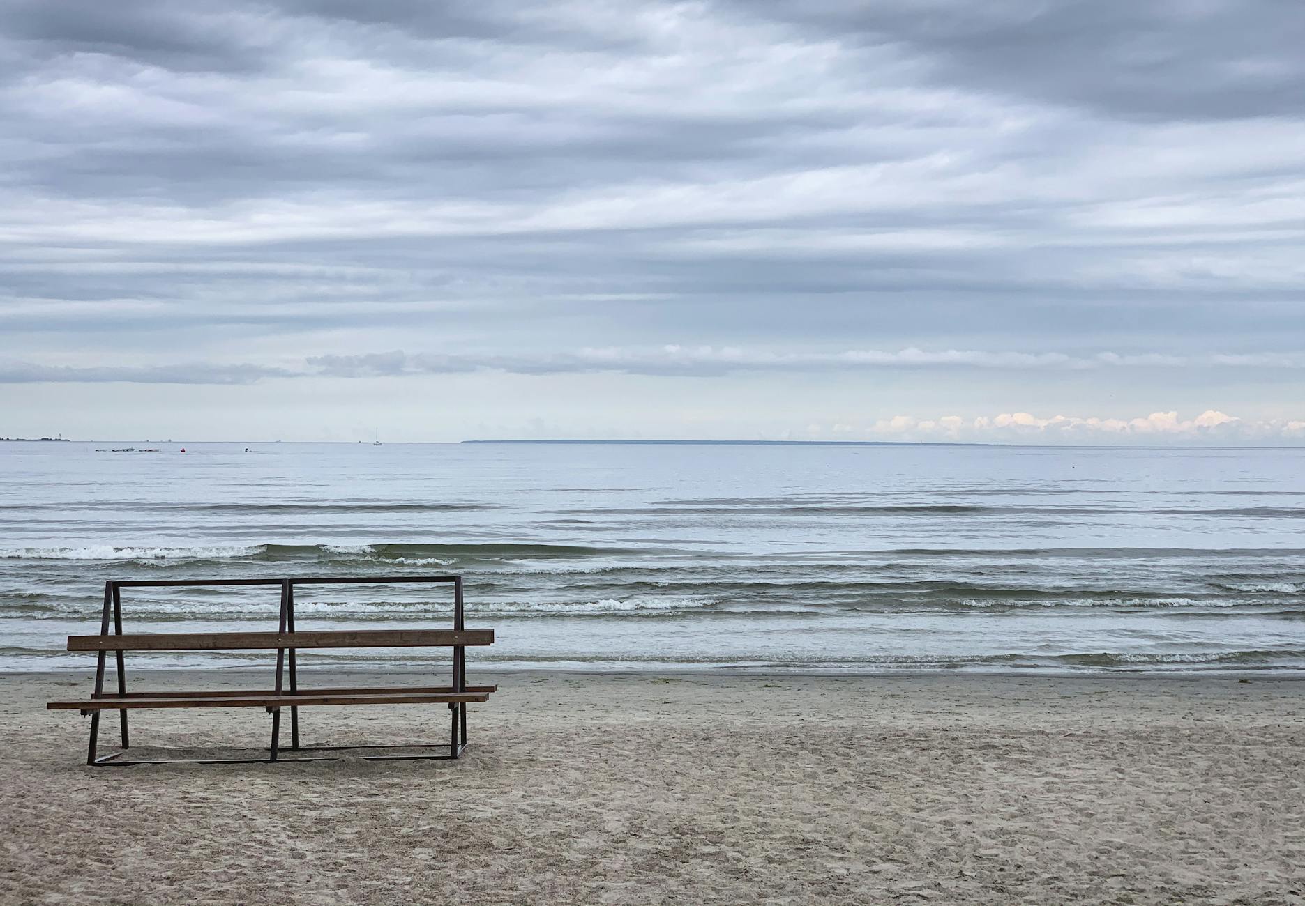 Pusta ławka nad spokojnym Bałtykiem w pochmurny dzień